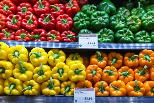 Sweet pepper in all colors: red, orange, yellow and green vegetables in the supermarket
