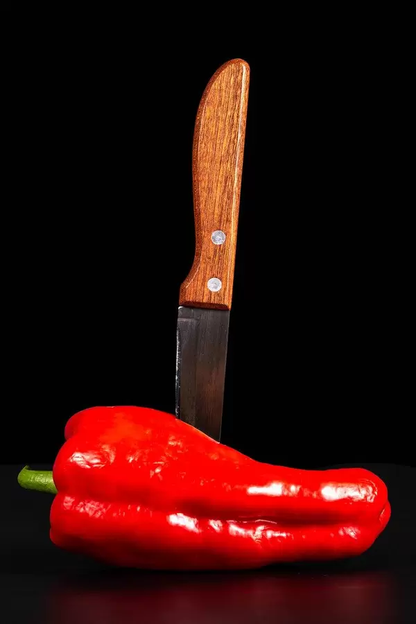 Sweet pepper with a knife on a black background