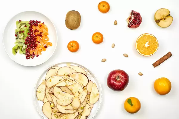 Sweet raw fruits and salads on white background