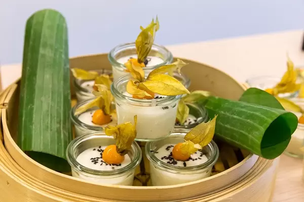 Sweet sticky rice with coconut milk, sesame & physalis, served in small glasses on a wooden tray, at AXA's Barcamp OMWest19 in Cologne, Germany