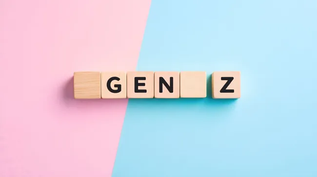 Symbolische Holzwürfel mit dem Begriff 'Gen Z' auf pastellfarbenem Hintergrund