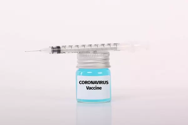 Syringe and bottle with blue fluid and Coronavirus Vaccine text