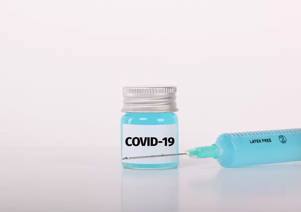 Syringe and bottle with blue fluid and Covid-19 text
