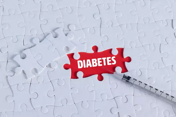 Syringe and missing puzzle pieces with a Diabetes text