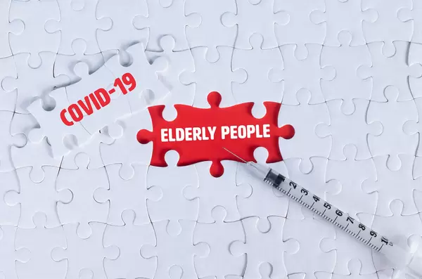 Syringe and missing puzzle pieces with text Covid-19 and Elderly people
