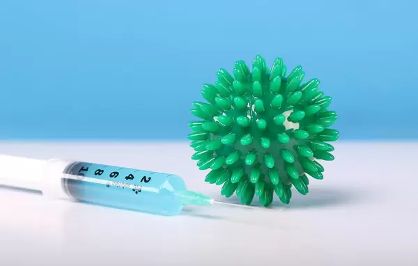 Syringe with blue fluid and Coronavirs bacteria