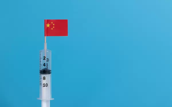 Syringe with flag of China on blue background