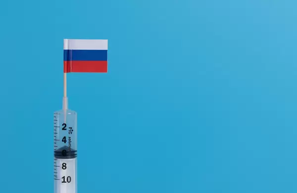 Syringe with flag of Russia on blue background