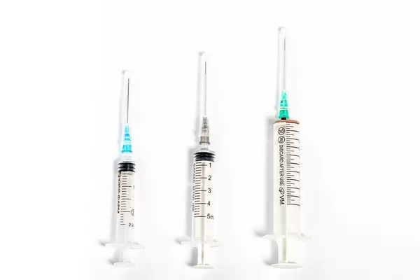 Syringes of different size on white background. Top view
