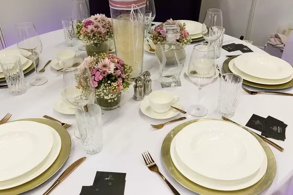 Table decoration for wedding with gold and white plates and pink flowers