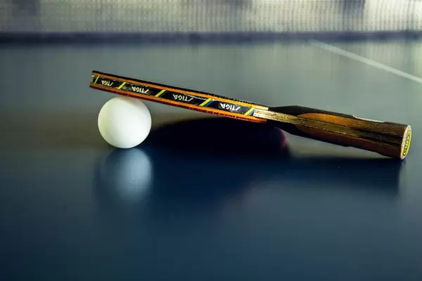 Table Tennis Paddle and Ball Resting on the Table