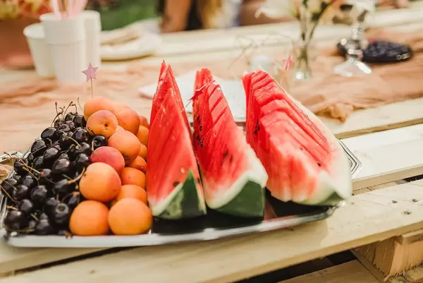 Tablett mit Wassermelone, Aprikosen und schwarzen Kirschen