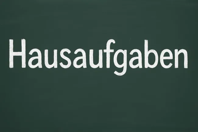 Tafel mit Aufschrift 'Hausaufgaben' in Kreide