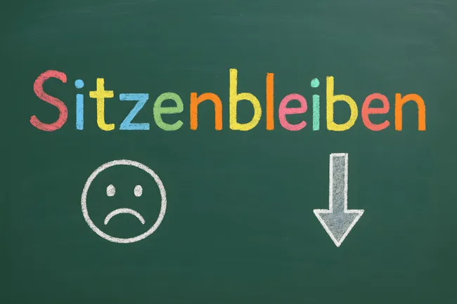 Tafel mit betrübtem Smiley und Pfeil nach unten