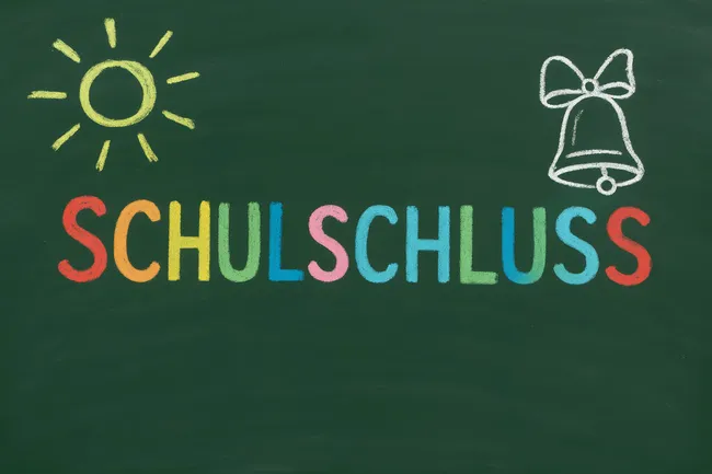 Tafel mit bunter Kreideaufschrift 'Schulschluss'