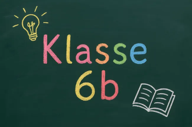 Tafel mit Klasse 6b, Glühbirne und Buch gezeichnet