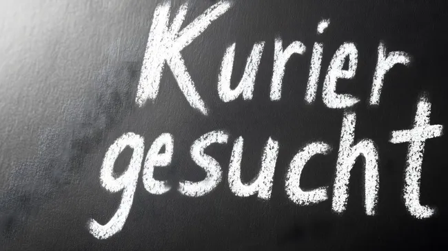 Tafel mit Kreideaufschrift 'Kurier gesucht'