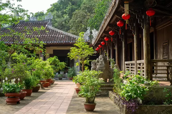 Tam Ton Pagoda with many Trees and Plants in Plant Pots, Red Lanterns and Statues of Chinese Guardian Lions at Marble Mountains in Danang, Vietnam