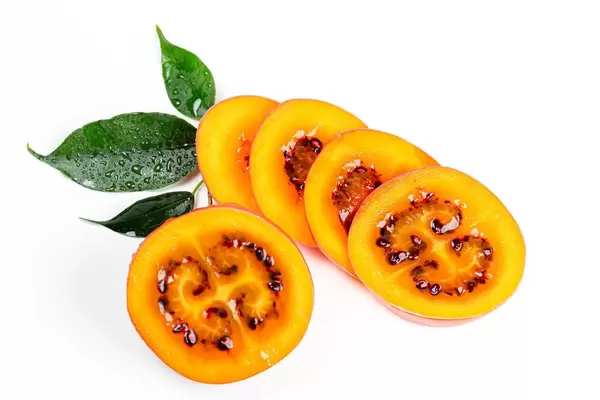 Tamarillo sliced and half on white background with leaves