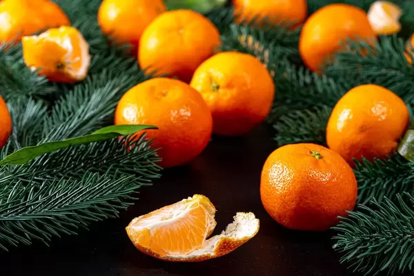 Tangerines with Christmas tree branches on a black background (Flip 2019)