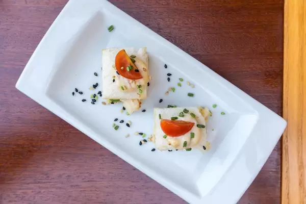 Tapas with tuna: Spanish appetizer with bread, cherry tomatoes and mixed seeds. Top view
