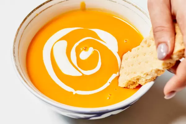 Tasting delicious creamy soup with a bread
