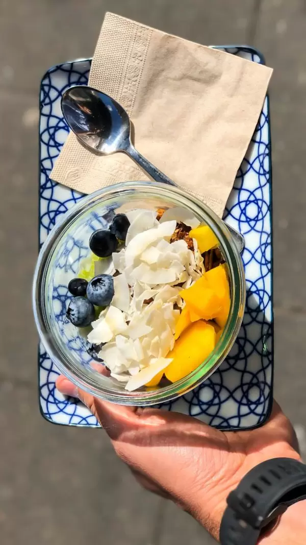 Tasty fruit salad: mango, blueberries, coconut flakes and granola
