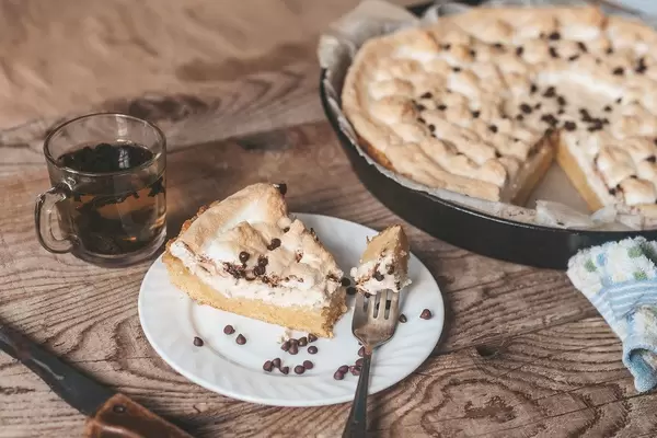 Tasty homemade cheesecake and cup of tea on wooden table