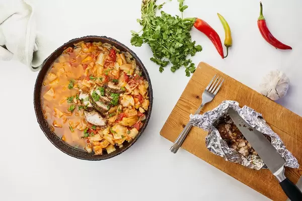Tasty lunch with borsch soup and baked chicken on the wood cutting board