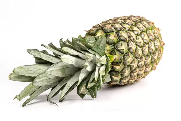 Tasty whole pineapple with leaves on white background