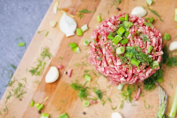 Tatarbeefsteak aus Rinderfleisch, mit grünen Kräutern, Knoblauch und Lauchzwiebel