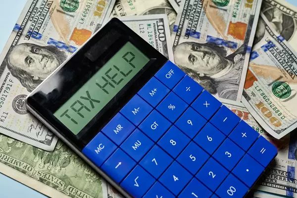 Tax help - calculator and stack of us dollar bills