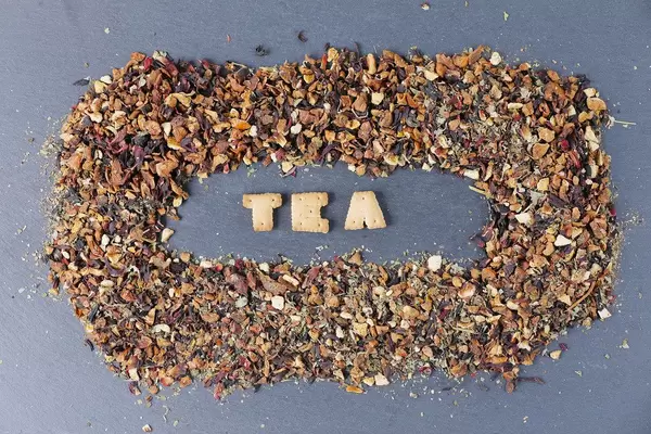 Tea biscuit letters in the middle of dry tea leaves
