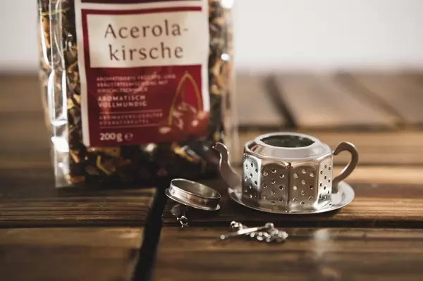 Tea dispenser with tea bag over a wooden surface