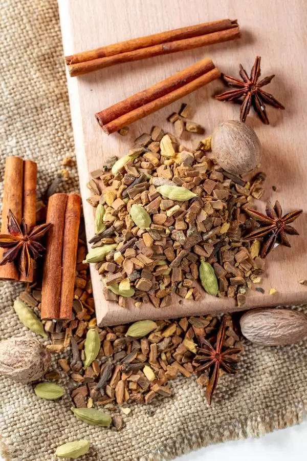 Tea with nutmeg, cloves, cinnamon sticks, star anise on a wooden Board