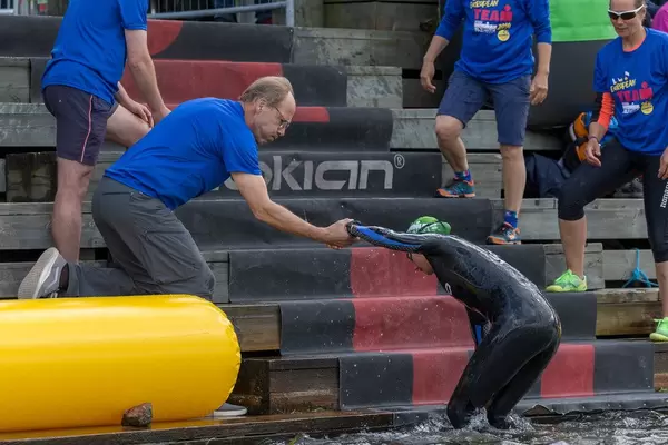 Team members of the Ironman 70.3. in Lahti helping a swimmer to get out of the water