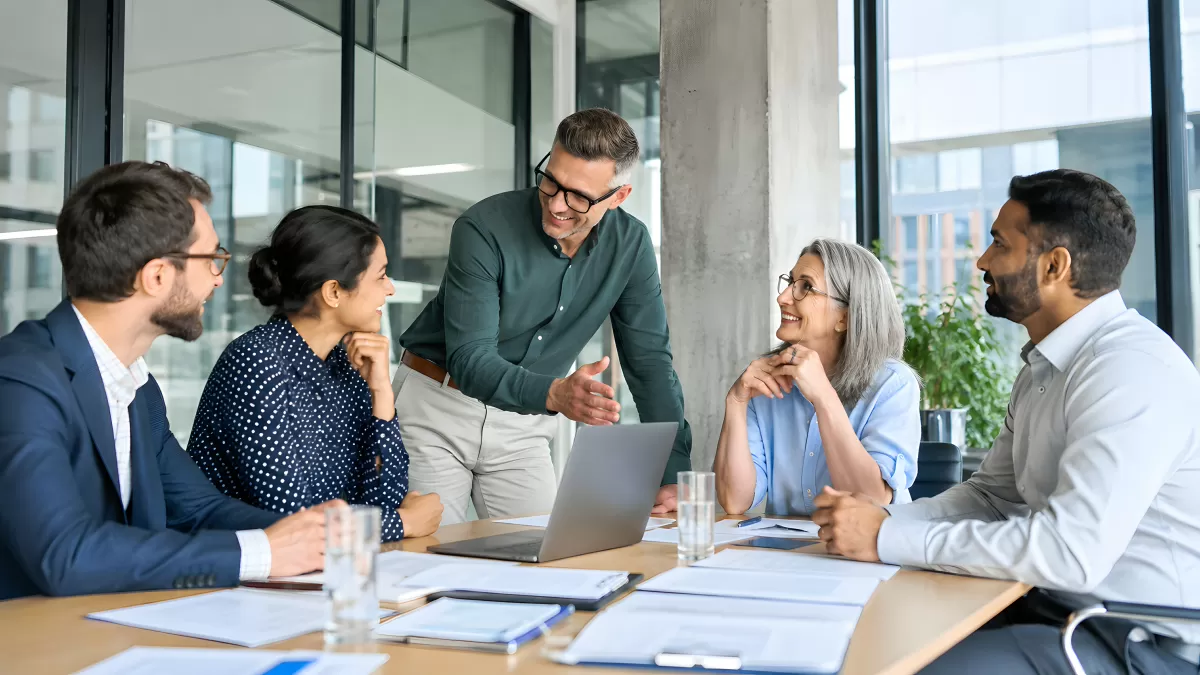 Teammeeting im modernen Büro mit fünf Kollegen