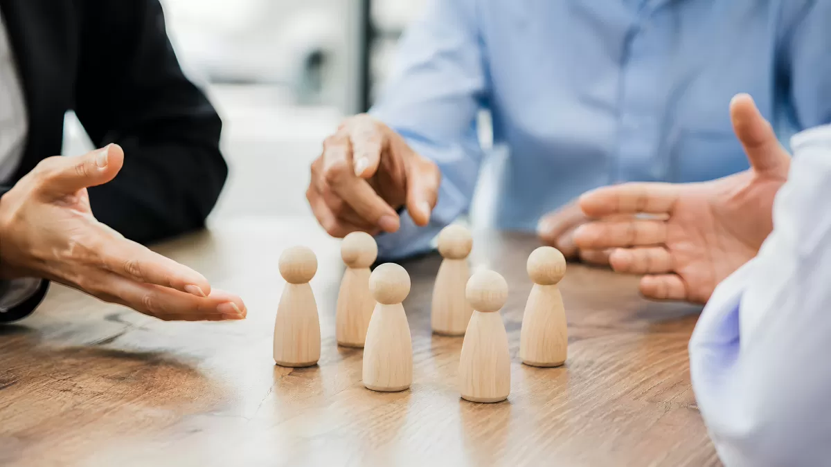 Teamstrategie mit Holzfiguren am Konferenztisch
