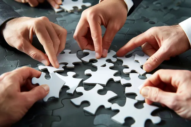 Teamwork-Puzzle - Geschäftsleute binden Teile zusammen