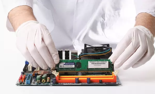 Technician installing RAM into the memory slot on a computer