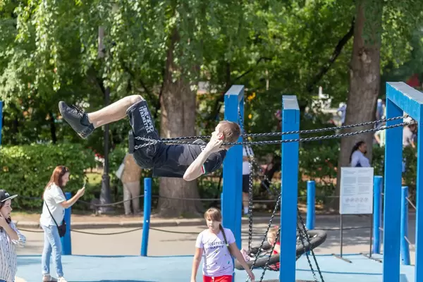 Teenager-Junge auf einer Schaukel im Gorki-Park