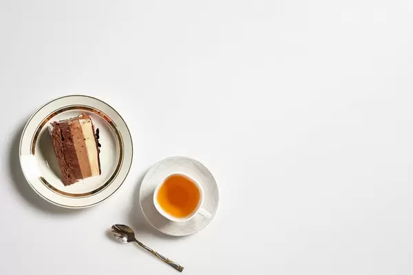 Teepause mit leckerer Torte: weißer Hintergrund mit Platz für Text rechts