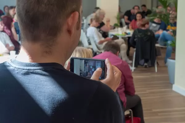 Teilnehmer filmt das Geschehen beim Barcamp mit seinem Handy