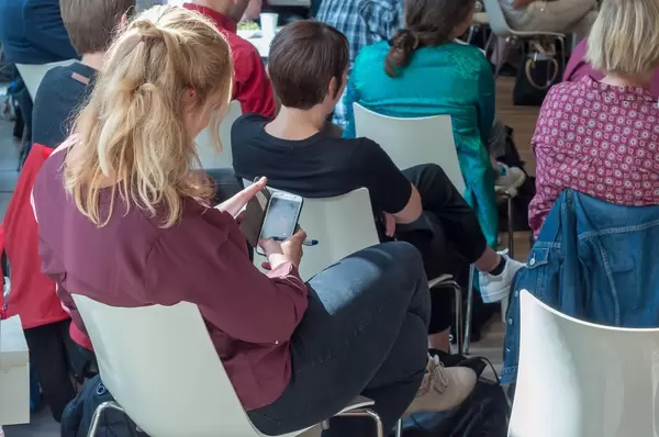 Teilnehmerin schaut auf ihr Handy