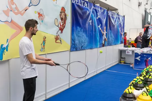Tennis Trainer Demonstration mit Schläger und Ball
