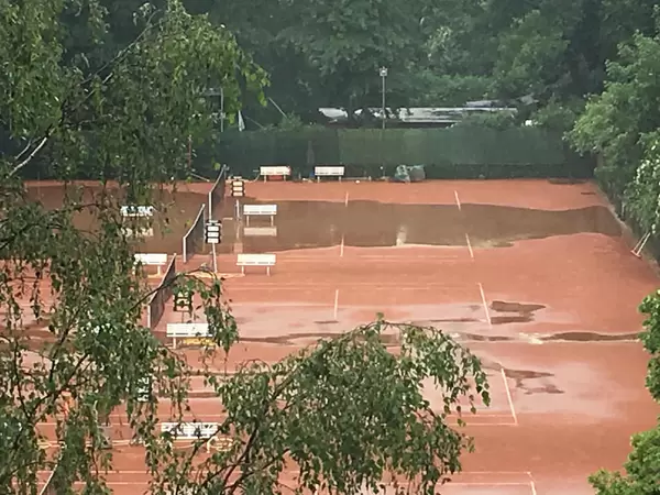 Tennisplatz im Regen überflutet.