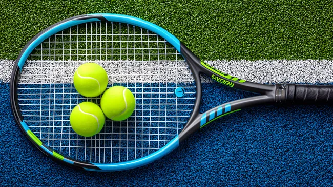 Tennisschläger mit Bällen auf Tennisplatz