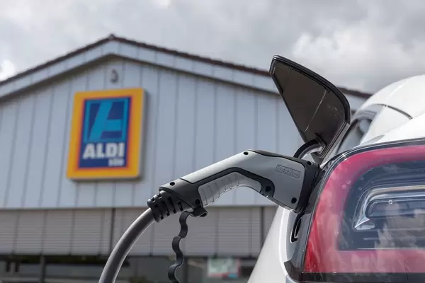 Tesla car Model 3 at a solar energy charging station, using a type 2 connector plug, on a parking lot of Aldi South, Germany