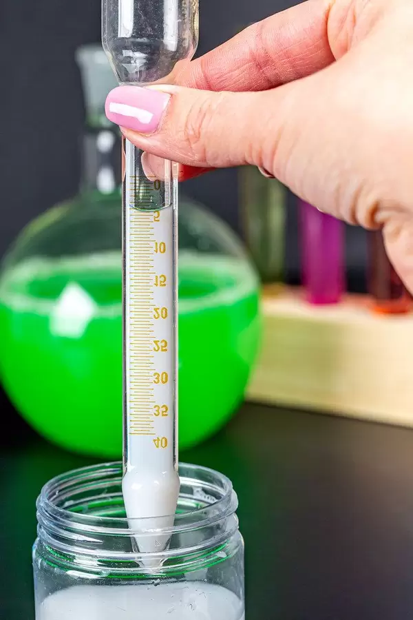 Test tube with scale and white liquid in hand (Flip 2020)