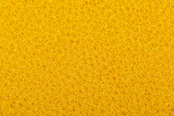 Texture of yellow sponge - medium cleaning element for aquarium filter, close up